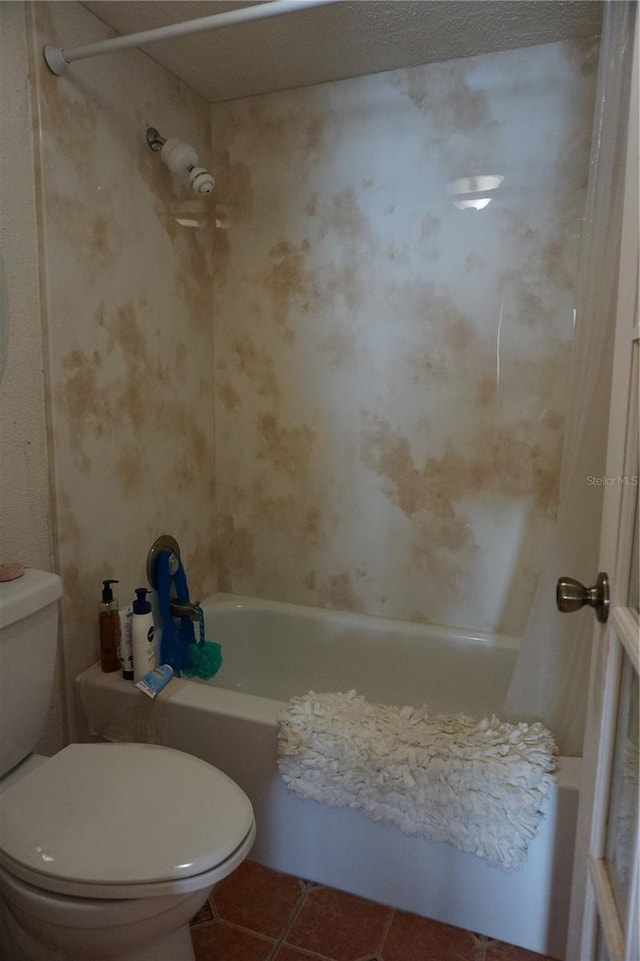 bathroom featuring tile patterned flooring, toilet, and shower / washtub combination