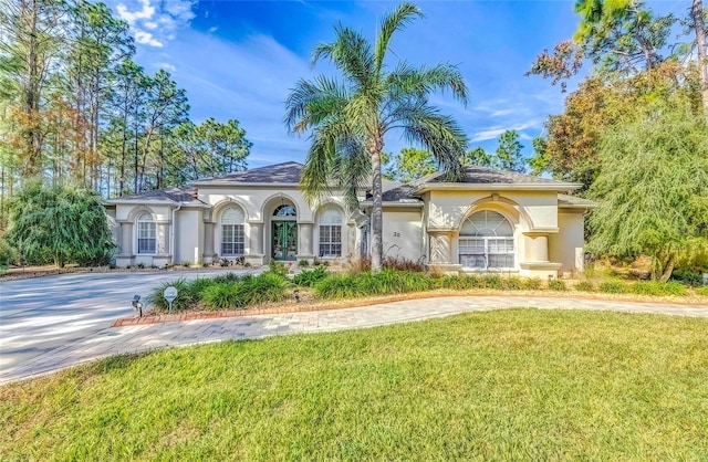 mediterranean / spanish house featuring a front lawn