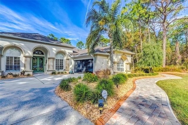 mediterranean / spanish home featuring a garage and french doors