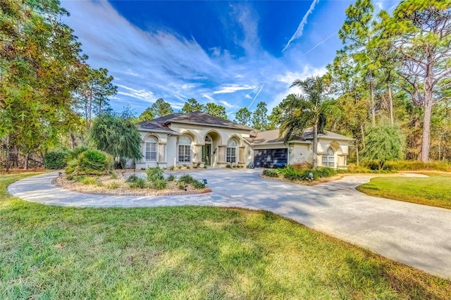 mediterranean / spanish house with a front yard and a garage