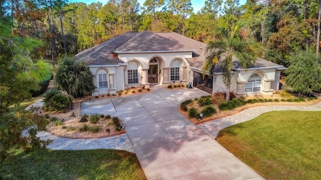 mediterranean / spanish-style home featuring a front yard and a garage