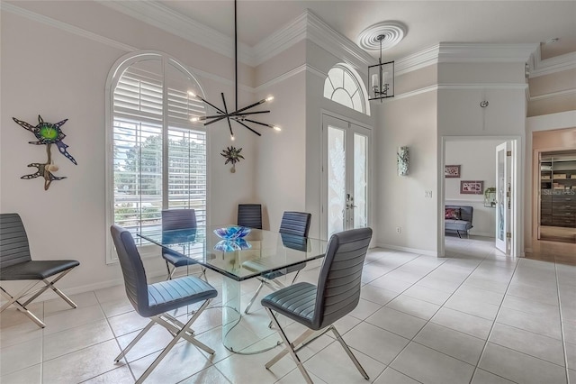 dining space with french doors, a towering ceiling, crown molding, and a notable chandelier