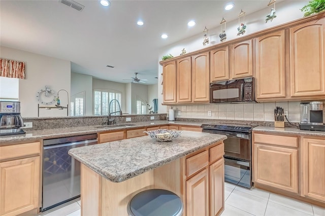 kitchen with black appliances, sink, ceiling fan, light tile patterned floors, and a kitchen island