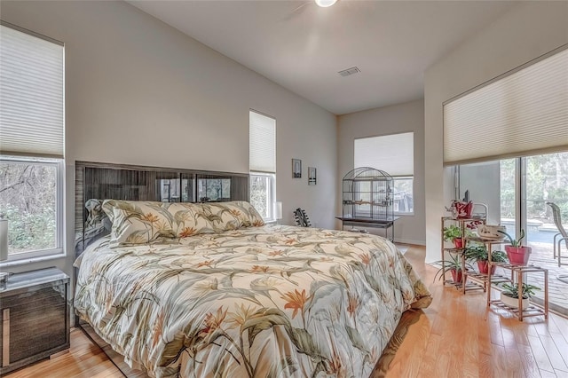 bedroom featuring light wood-type flooring, access to outside, and multiple windows