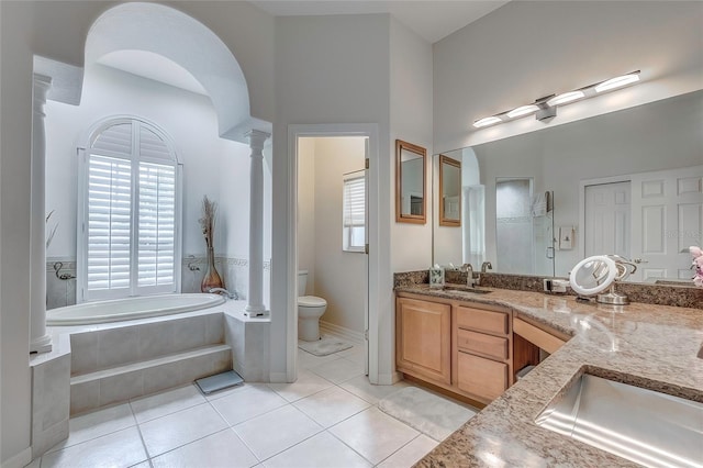 full bathroom featuring plus walk in shower, tile patterned flooring, decorative columns, toilet, and vanity