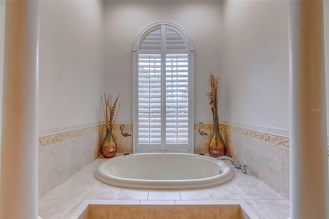 bathroom with a healthy amount of sunlight and tiled tub