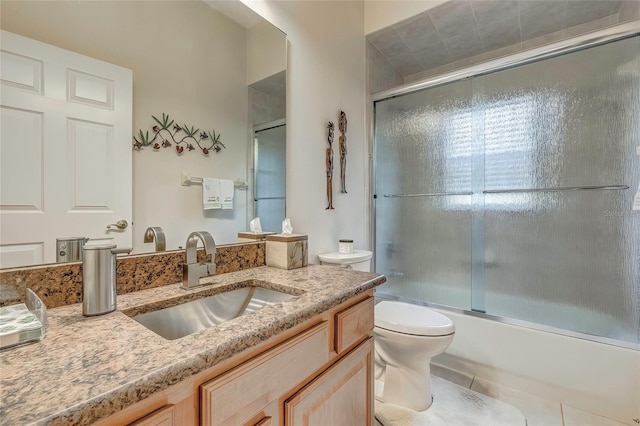 full bathroom with tile patterned floors, vanity, toilet, and shower / bath combination with glass door