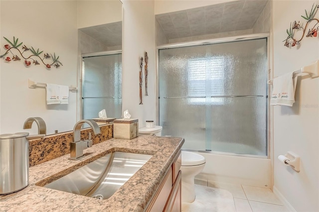 full bathroom featuring toilet, vanity, tile patterned floors, and shower / bath combination with glass door