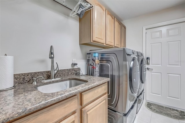 laundry area featuring washer and dryer, cabinets, light tile patterned floors, and sink