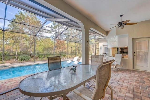 view of patio featuring exterior bar, glass enclosure, and ceiling fan