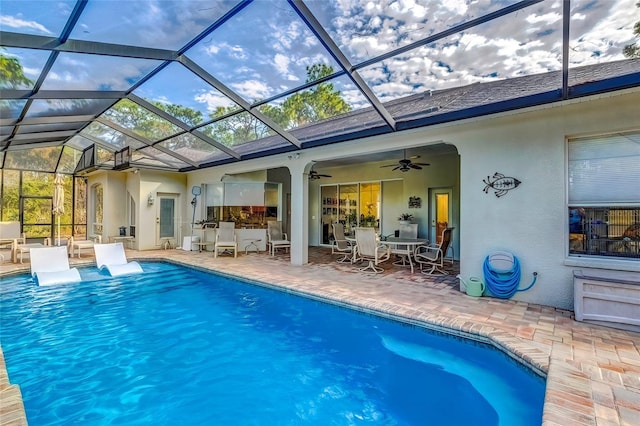 view of pool featuring ceiling fan, a patio area, and a lanai