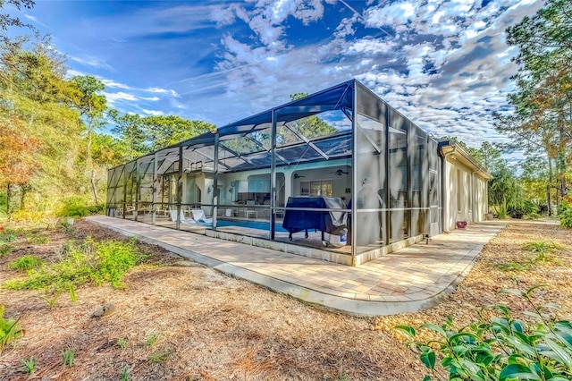 rear view of house with ceiling fan and a lanai