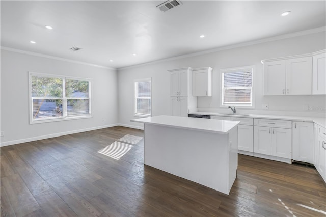 kitchen featuring a healthy amount of sunlight, sink, a center island, and white cabinets