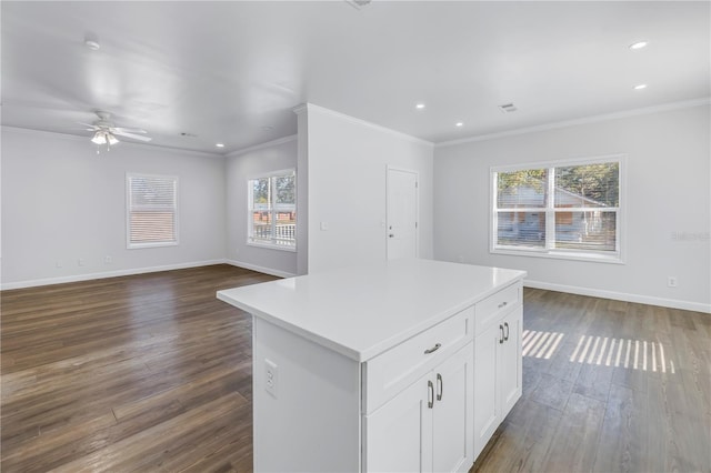 kitchen with crown molding, ceiling fan, dark hardwood / wood-style floors, white cabinets, and a kitchen island