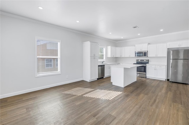 kitchen featuring a kitchen island, appliances with stainless steel finishes, dark wood-type flooring, and white cabinets