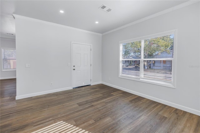 spare room with ornamental molding, a wealth of natural light, and dark hardwood / wood-style flooring