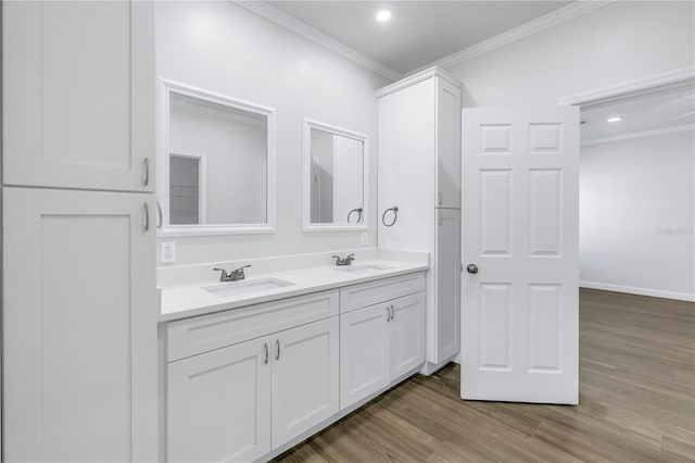 bathroom with crown molding, hardwood / wood-style floors, and vanity