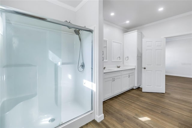 bathroom featuring an enclosed shower, vanity, wood-type flooring, and ornamental molding