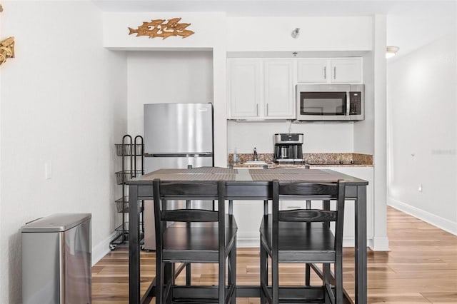 kitchen featuring light hardwood / wood-style floors, white cabinetry, and stainless steel appliances