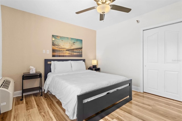 bedroom featuring ceiling fan, a closet, and light wood-type flooring