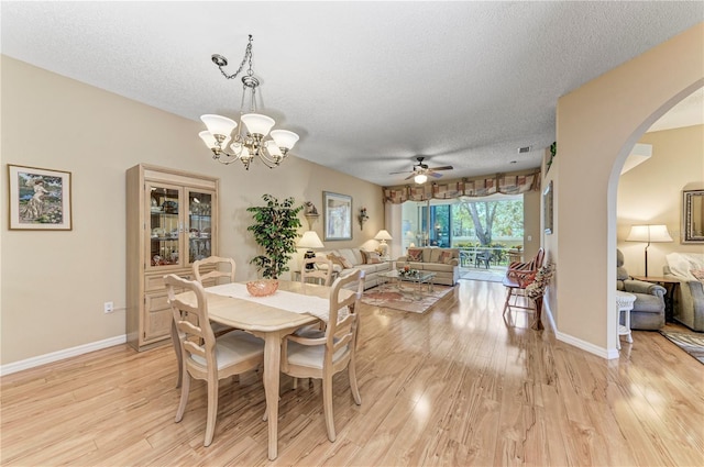 dining room featuring a textured ceiling, ceiling fan with notable chandelier, and light hardwood / wood-style floors