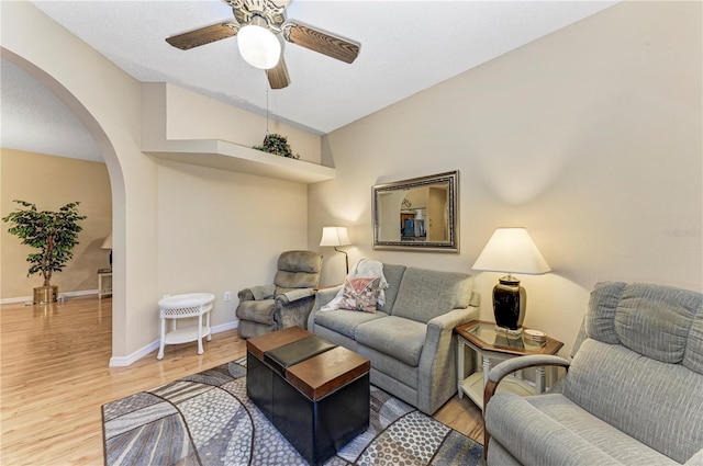 living room featuring wood-type flooring, vaulted ceiling, and ceiling fan