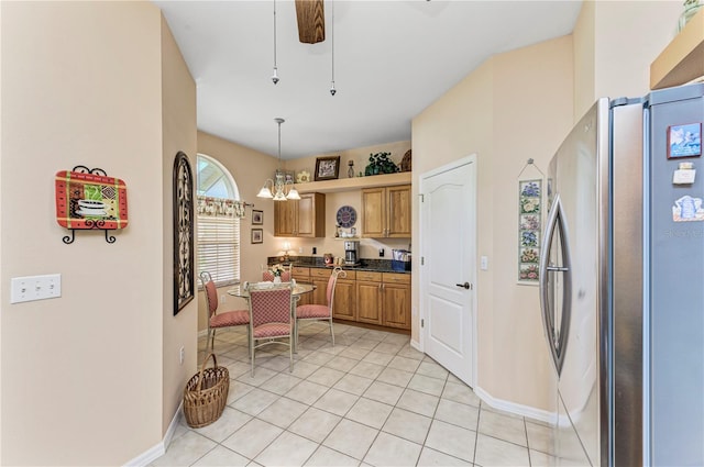 kitchen featuring stainless steel refrigerator, ceiling fan with notable chandelier, light tile patterned floors, and decorative light fixtures