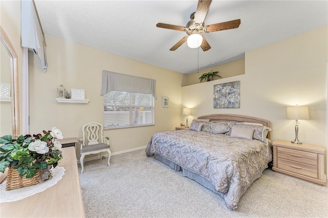 bedroom featuring a textured ceiling, light colored carpet, and ceiling fan