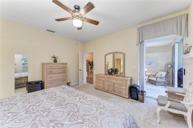 bedroom with a textured ceiling, ceiling fan, and light carpet