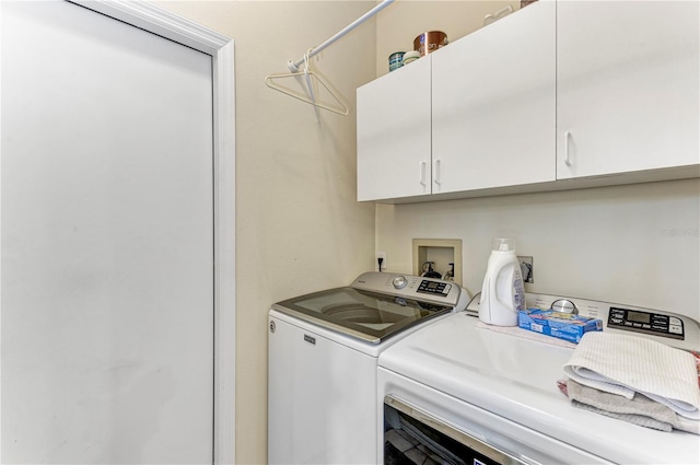 washroom featuring cabinets and independent washer and dryer