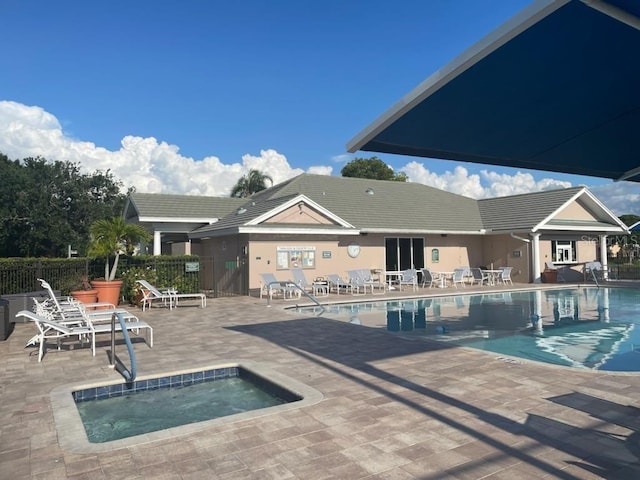 view of swimming pool with a patio area and a hot tub