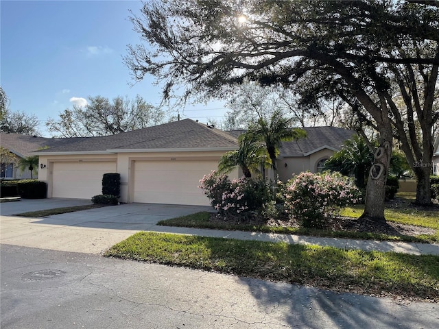6325 Stone River Rd, Bradenton, FL 34203 - view of front of home with stucco siding, a garage, driveway, and a shingled roof