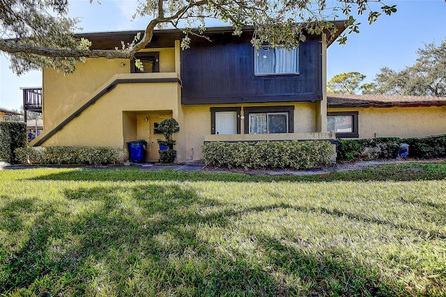 view of front facade featuring a balcony and a front lawn