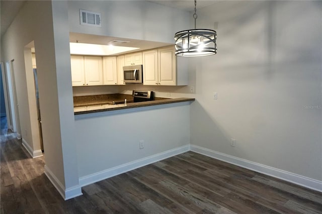 kitchen with white cabinetry, hanging light fixtures, an inviting chandelier, kitchen peninsula, and appliances with stainless steel finishes