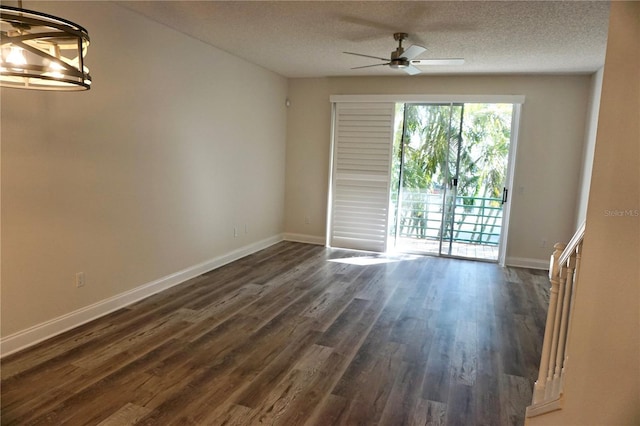 spare room featuring a textured ceiling, dark hardwood / wood-style floors, and ceiling fan with notable chandelier