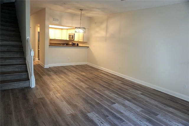 unfurnished living room with dark hardwood / wood-style flooring