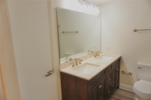 bathroom with vanity, wood-type flooring, and toilet