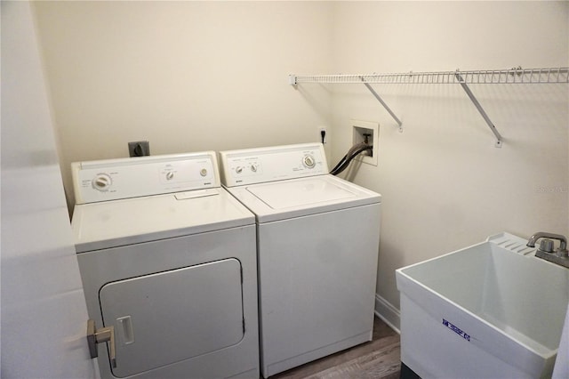 laundry room featuring dark hardwood / wood-style floors, washer and clothes dryer, and sink