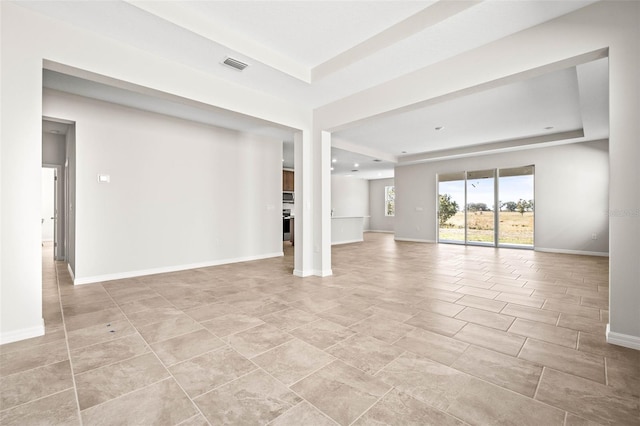 unfurnished living room with a tray ceiling