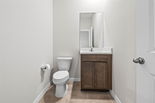 bathroom with tile patterned flooring, vanity, and toilet