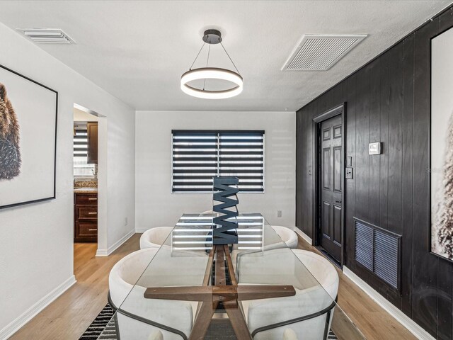 2000 57th St N, Saint Petersburg, FL 33710 - dining space featuring light hardwood / wood-style flooring and wood walls