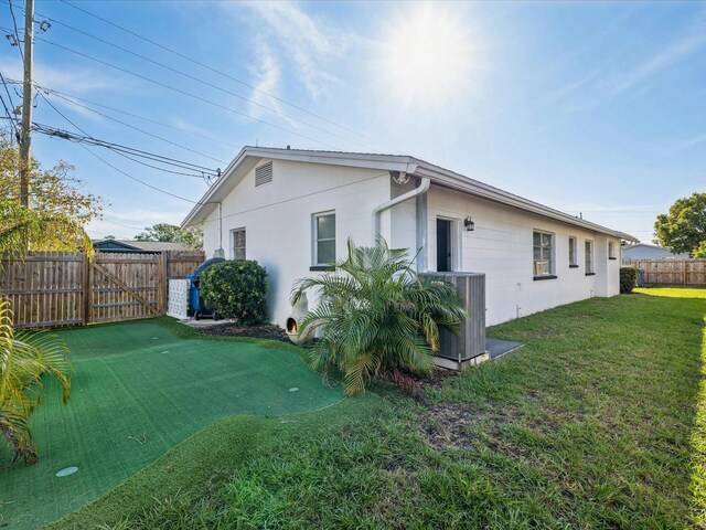 2000 57th St N, Saint Petersburg, FL 33710 - back of property featuring central air condition unit and a lawn