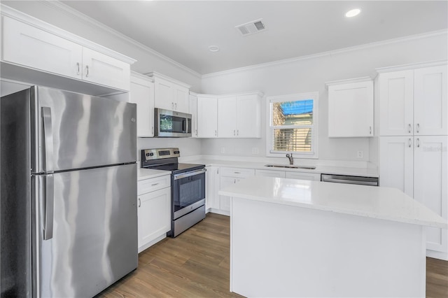 kitchen with sink, crown molding, a center island, stainless steel appliances, and white cabinets