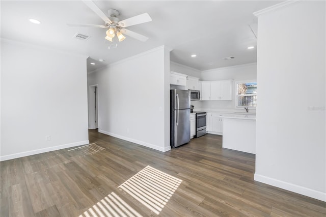 interior space featuring sink, crown molding, appliances with stainless steel finishes, white cabinetry, and dark hardwood / wood-style floors