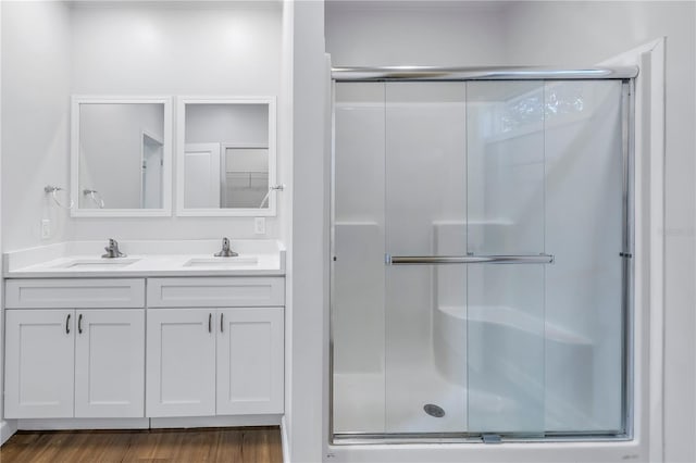 bathroom with a shower with door, vanity, and hardwood / wood-style flooring