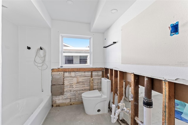 bathroom with a bathtub, concrete floors, and toilet