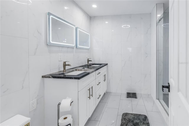 bathroom with vanity, tile walls, and walk in shower