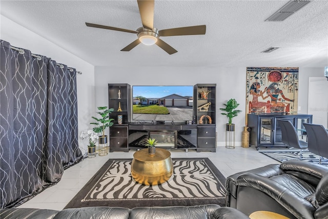 living room with a textured ceiling and ceiling fan