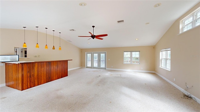 unfurnished living room featuring french doors, light colored carpet, vaulted ceiling, and ceiling fan