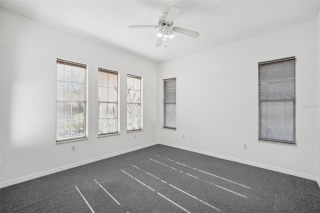 carpeted spare room featuring ceiling fan